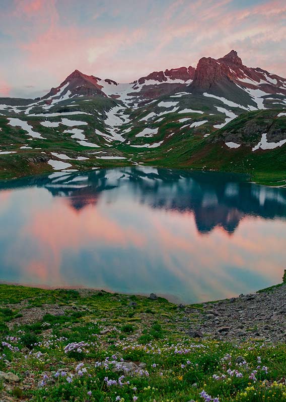 A small lake surrounded by alpine meadow.