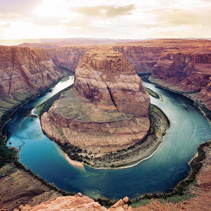 An aerial view of a river bending between tall canyon cliffs.